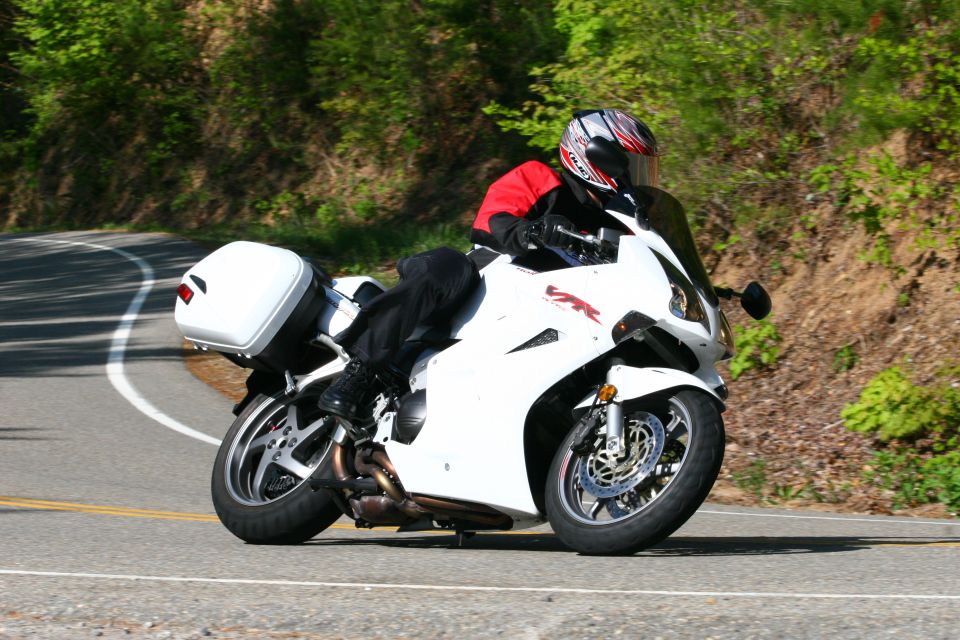 Action photo of a white Honda VFR cornering with luggage