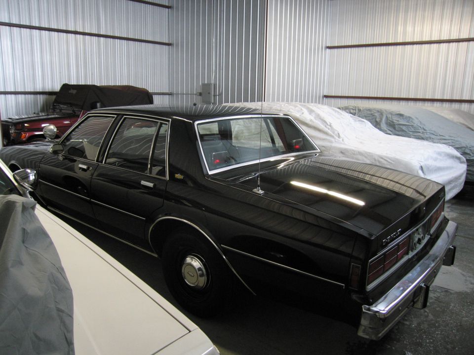 Rear three-quarter view of a black Chevrolet Caprice in storage