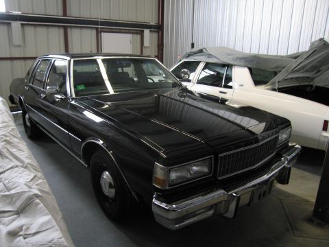 1991 Ford LTD Crown Victoria - Photograph of a black Chevrolet Caprice sedan parked in a storage building, not a technical document.