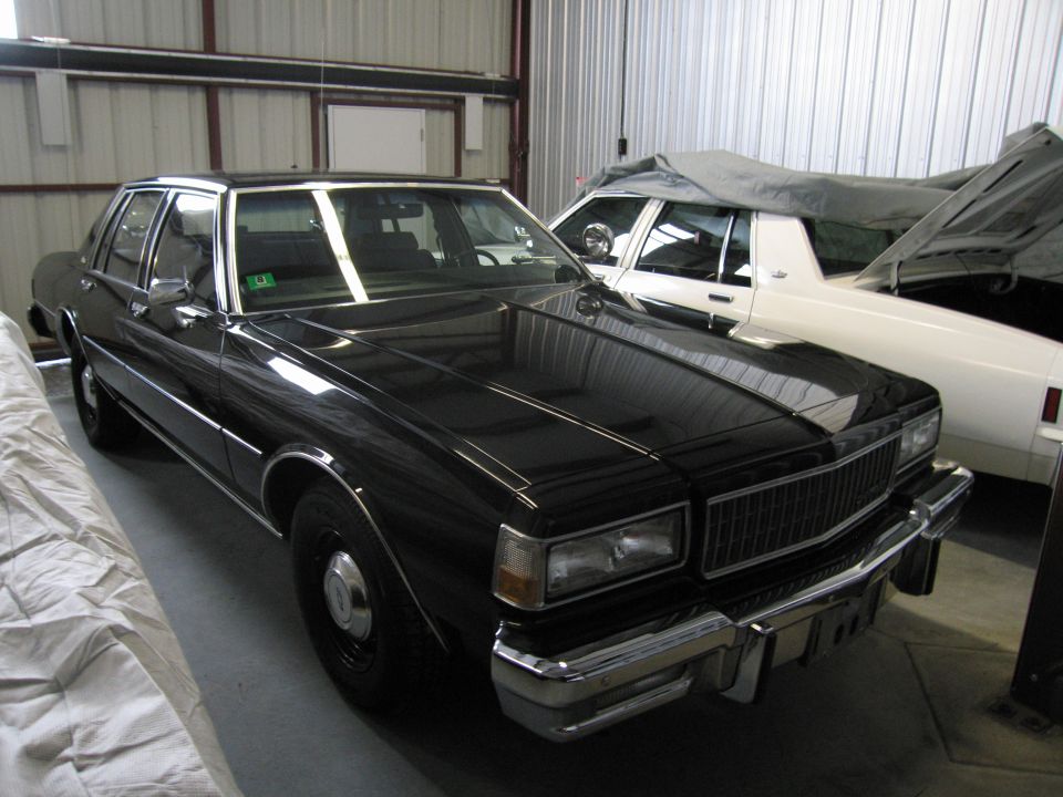 Front three-quarter view of a black Chevrolet Caprice in storage