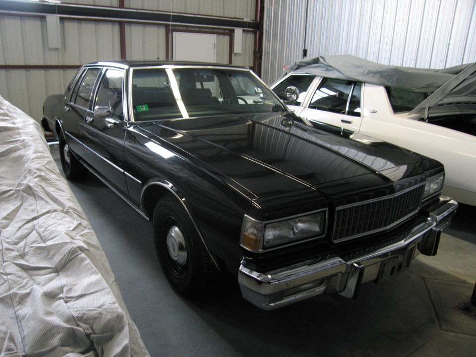 Black Chevrolet Caprice front three-quarter view in a warehouse