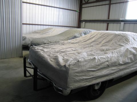 1991 Ford LTD Crown Victoria - Photograph of covered vehicles stored in a warehouse, not a technical document.