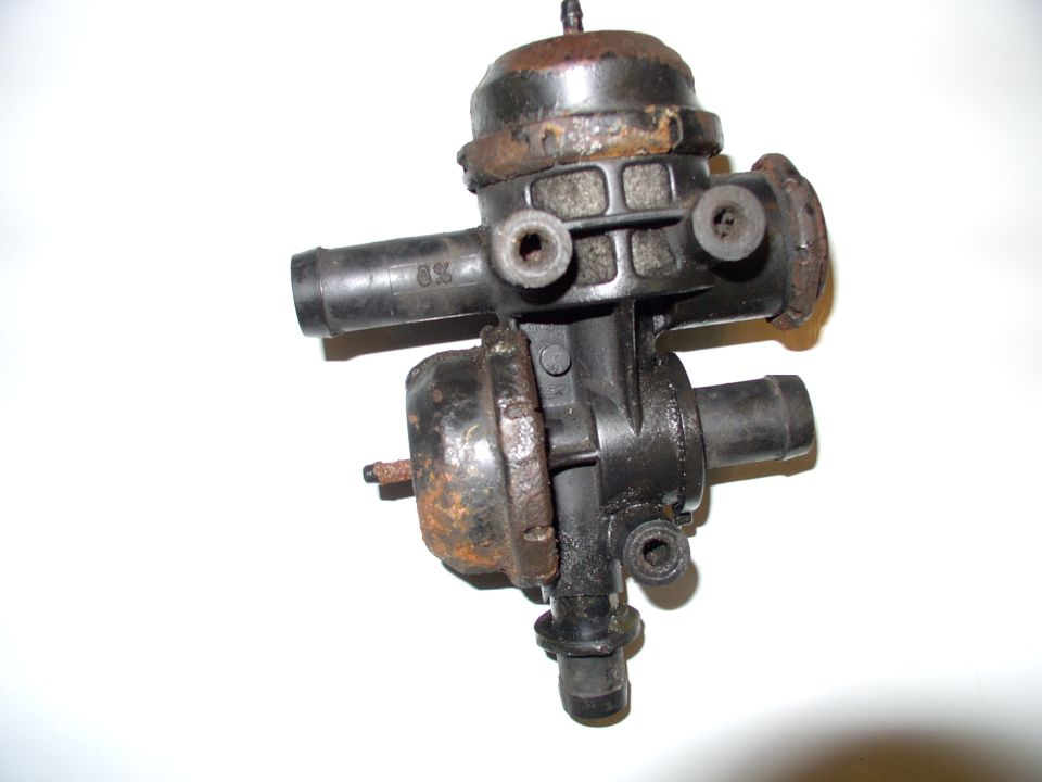 Used dual vacuum diaphragm valve assembly with rusty surfaces on white background