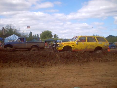 1976 Ford F-100 - Two vehicles are stuck in the mud at a race event.