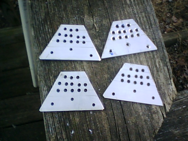 four white triangular plates with black text, resting on a wooden surface