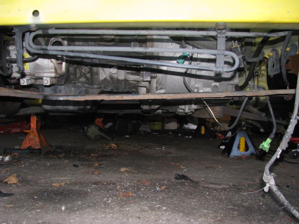 Underside of car on jack stands, showing engine and exhaust components