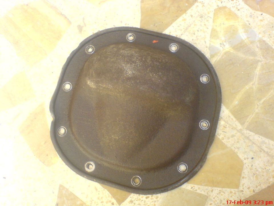 Differential cover with gasket and bolts on a tiled floor