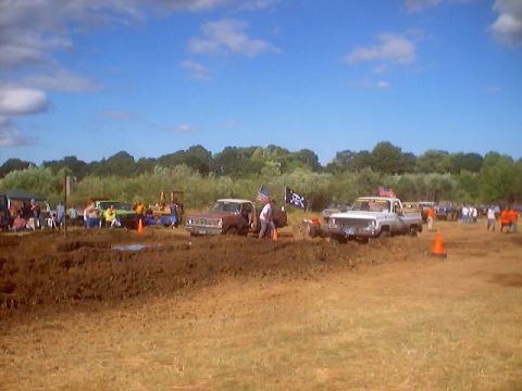 1976 Ford F-100 - Trucks participating in a mud bog event with spectators gathered around.