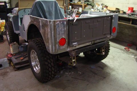 1948 Jeep Wrangler - This Jeep pickup truck is in a workshop, possibly being restored or modified. The rear section is visible.