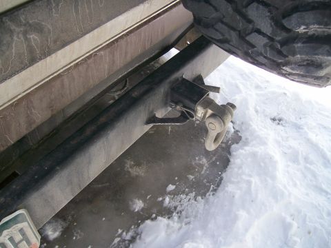 1993 Ford Bronco - Close-up of a vehicle's rear bumper, tow hitch, and spare tire in a snowy environment.