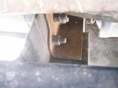 1993 Ford Bronco - Close-up of a rusted metal bracket and bolts, likely from a vehicle's undercarriage.