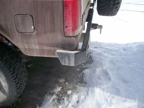 1993 Ford Bronco - Close-up of an aftermarket rear bumper and tire mount on a vehicle, with snow covering the ground.