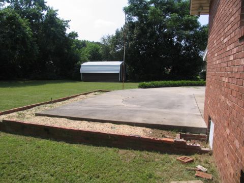 1978 Ford Bronco - A backyard features a shed, a concrete patio, and a portion of a brick house.