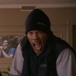 2004 Chevrolet Silverado 1500 - A man wearing a beanie and vest is captured in a moment of intense emotion, yelling with his mouth wide open.