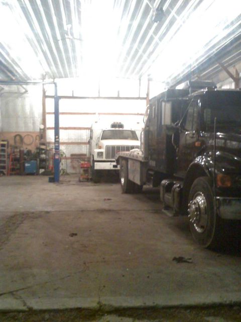 1992 Ford Bronco - Two trucks are parked inside a garage, one in the foreground and another in the background.