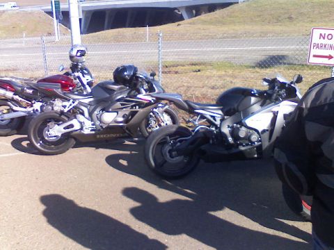 2008 Kawasaki Ninja R - Multiple sport motorcycles are parked outdoors near a road, with a 'No Parking' sign visible.