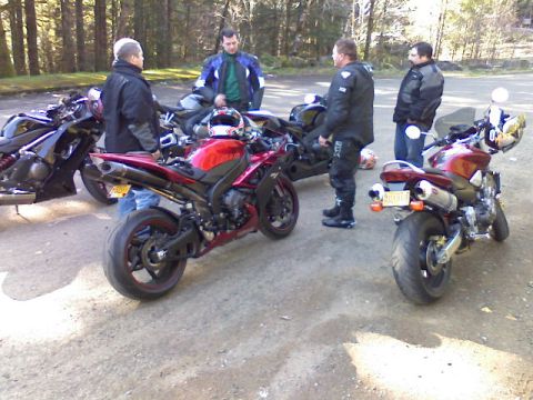 2008 Kawasaki Ninja R - A group of motorcyclists gather around their bikes in a wooded area.