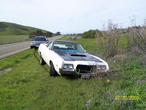 1972 Ford Ranchero - A white 1972 Ford Ranchero GT with a black hood is parked off the side of the road next to another vehicle.