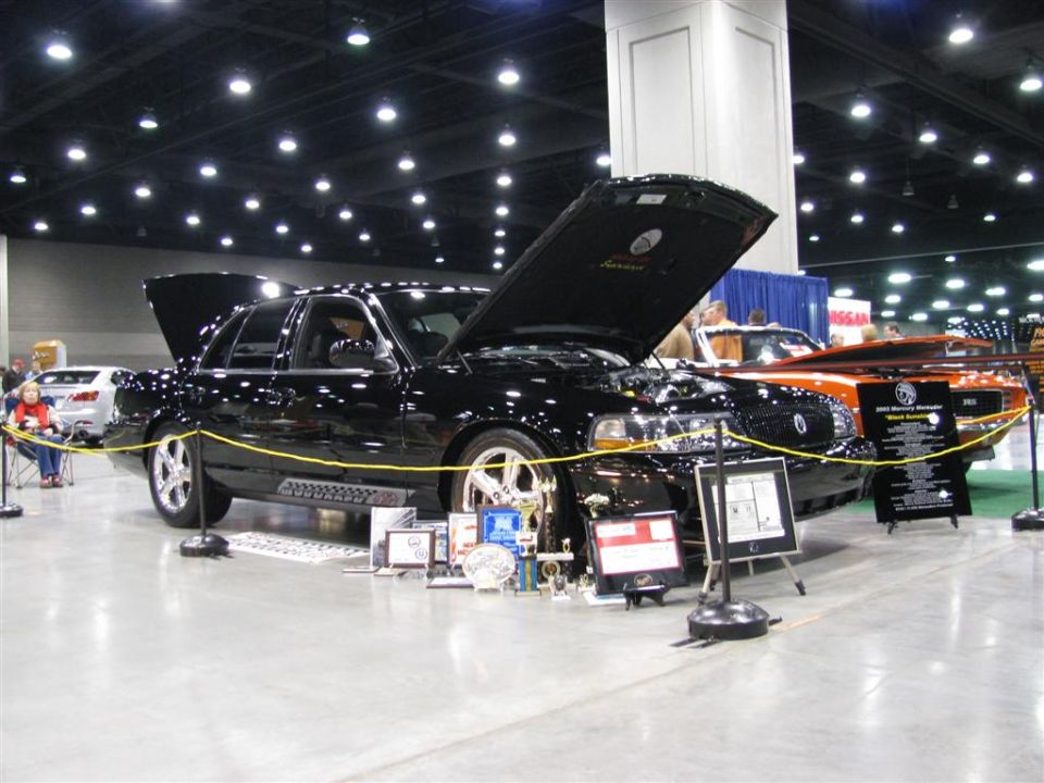 Black 2003 Mercury Marauder with hood open, trophies displayed in front