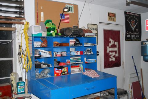 2008 Jeep Wrangler - A blue steel workbench with a cubby-shelf hutch in a garage, loaded with hardware, manuals, trash bags and shop odds and ends. The wall beh…