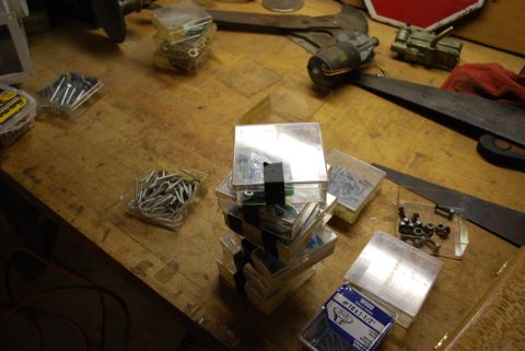2008 Jeep Wrangler - Assorted hardware and tools are organized in containers on a wooden workbench.