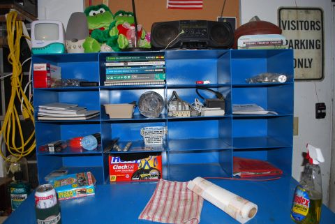 2008 Jeep Wrangler - A blue metal cubby shelf unit in a garage holds Haynes repair manuals for Ford and Dodge pickups along with light bulbs, extension cords, t…