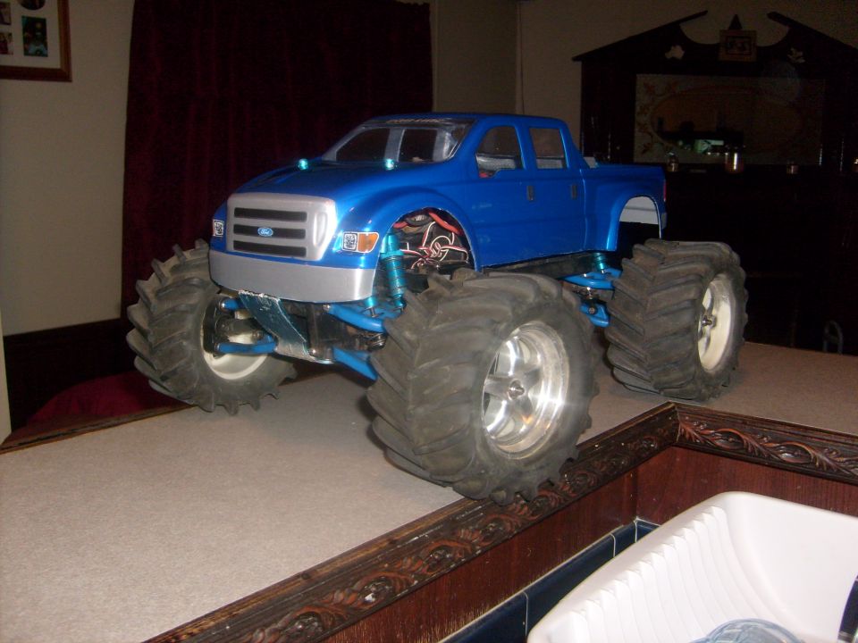 Blue RC monster truck with oversized tires and a Ford grille