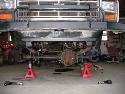 1985 Ford Bronco - Undercarriage view of a truck, possibly a Ford Bronco, undergoing maintenance.