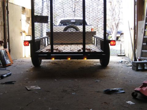 2004 Ford F-150 - A trailer is hitched to a vehicle, seen from the rear inside a garage. The license plate is visible.