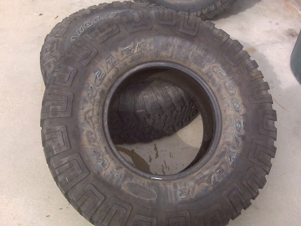 Two Goodyear Wrangler tires stacked, one on top of the other. Tread pattern is visible
