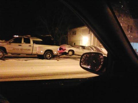 2003 Ford Crown Victoria - A tow truck is seen pulling a car on a snowy road at night, with a building in the background.