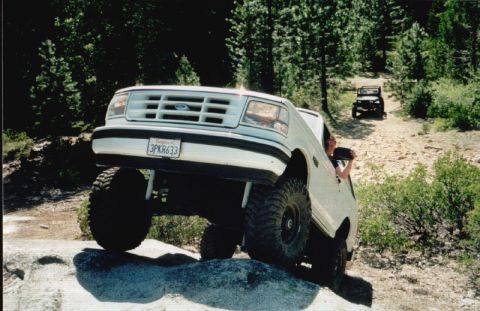 1996 Ford Bronco - 1996 Ford Bronco navigating a boulder obstacle on an off-road trail.