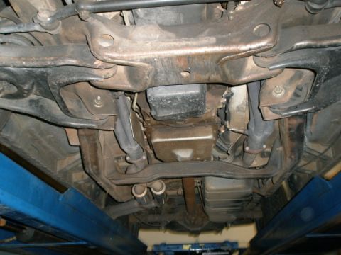 2007 Ford Mustang - Photograph of a vehicle undercarriage on a lift showing crossmember, oil pan and exhaust, not a document.