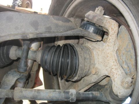 2007 Ford Mustang - Photograph of a front suspension assembly with CV axle boot, control arm and tie rod, not a document.