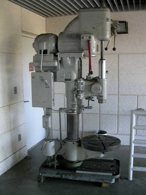 1990 Ford Bronco - A large industrial drill press is shown in a room with tiled walls and a metal ceiling.