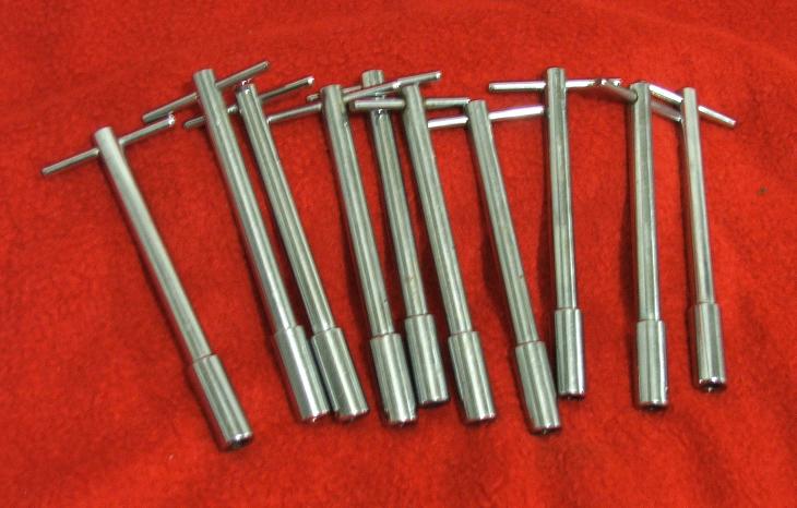 Ten T-handle hex wrenches on a red surface