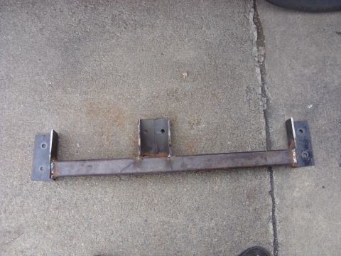 1988 Ford Bronco - A custom-fabricated steel bracket with two mounting plates is shown lying on a concrete surface. The bracket appears to be a part for a veh…