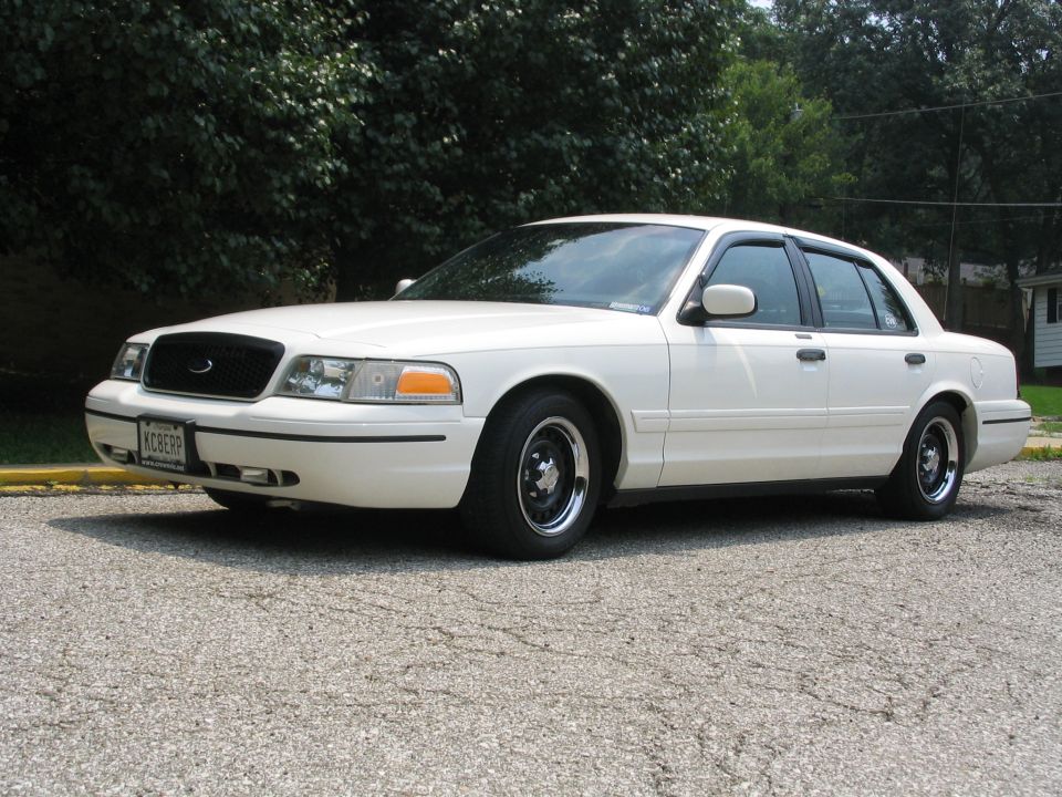 White 1998 Ford Crown Victoria sedan, front quarter view, black grille, chrome wheels, license plate KCBERP