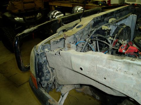 2000 Ford E350 - The front end of a disassembled vehicle, likely a van or truck, is shown with the engine compartment exposed. Visible parts include the rad…
