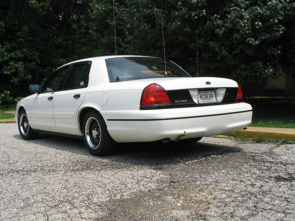White 1998 Ford Crown Victoria, rear view with license plate KCBERP