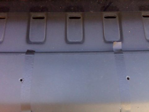 2008 Jeep Wrangler - A close-up view of the textured plastic exterior of a vehicle, showing three recessed rectangular slots at the top and two small holes belo…