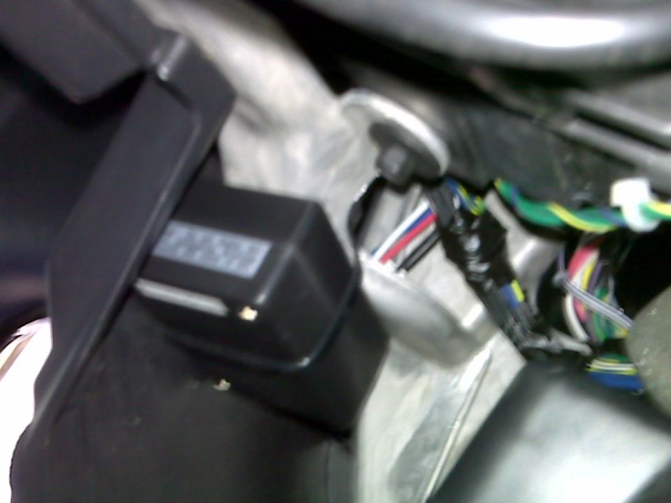Close-up of a black electronic module with a white label and colorful wires.
