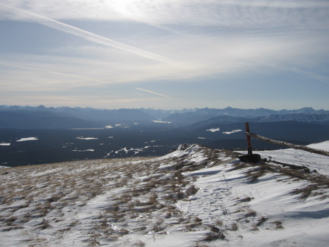 Snowy mountain landscape with valley and distant mountains.