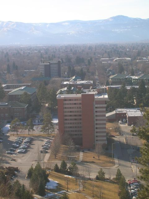 1996 Ford Bronco - A wide aerial view of a university campus with several multi-story brick buildings and a large parking lot filled with cars. Mountains are…