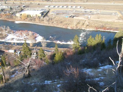 1996 Ford Bronco - An aerial view shows a wide, dark river flowing through a landscape with snow patches on the banks and a distant industrial area with build…