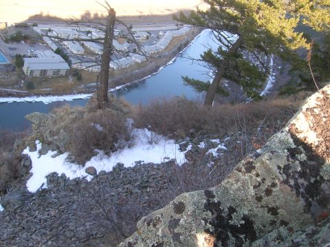 1996 Ford Bronco - A scenic view from a rocky cliff overlooking a winding river and a residential area with apartment buildings.