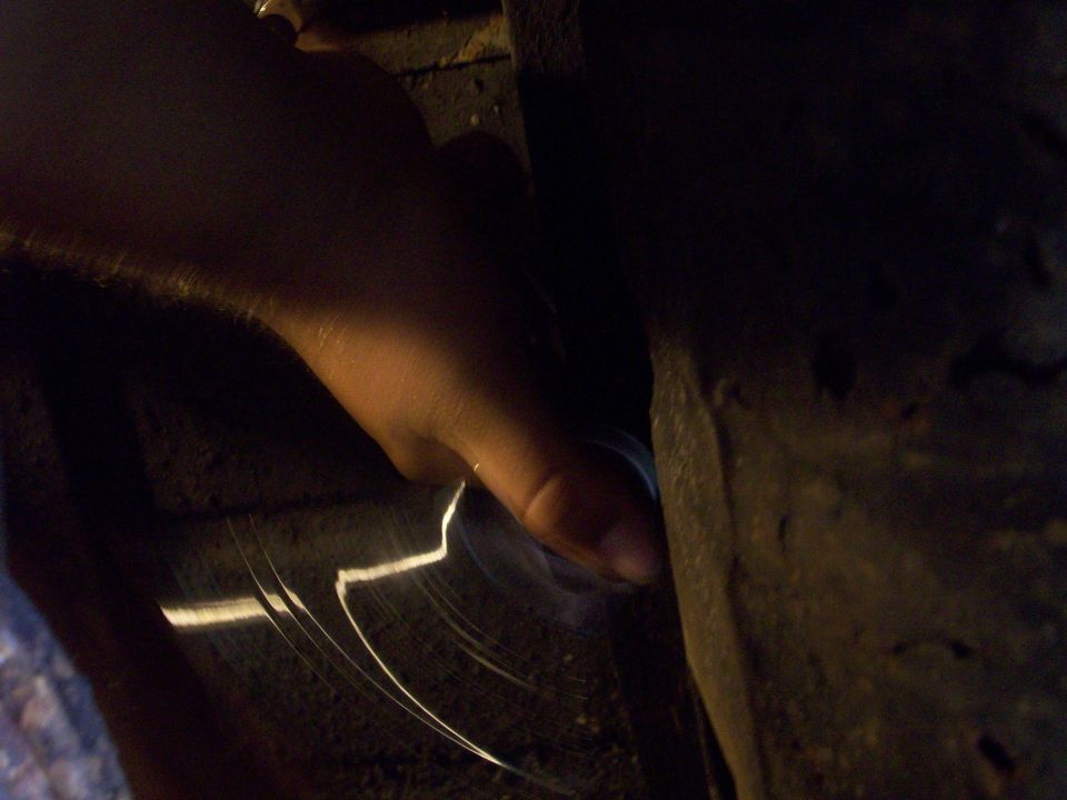 Person's hand in foreground, blurred dark background with light streaks.