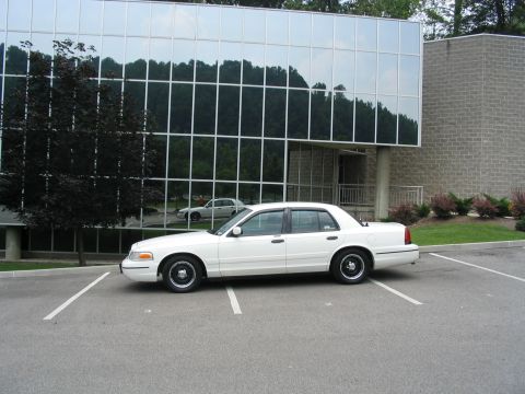1998 Ford Crown Victoria - Side view of a white 1998 Ford Crown Victoria parked in a lot.