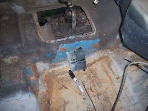 1978 Jeep CJ5 - Interior view of a vehicle's floor pan, revealing the transmission tunnel and a metal plate with handwritten notes.