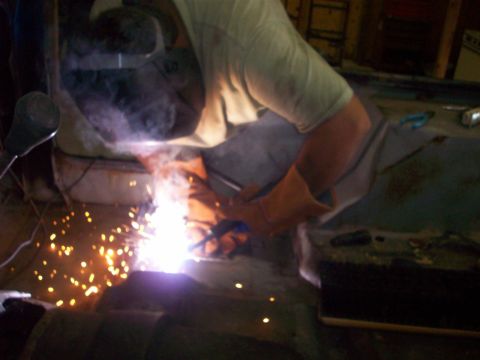 1978 Jeep CJ5 - Welding sparks illuminate the scene as a person works on a project.
